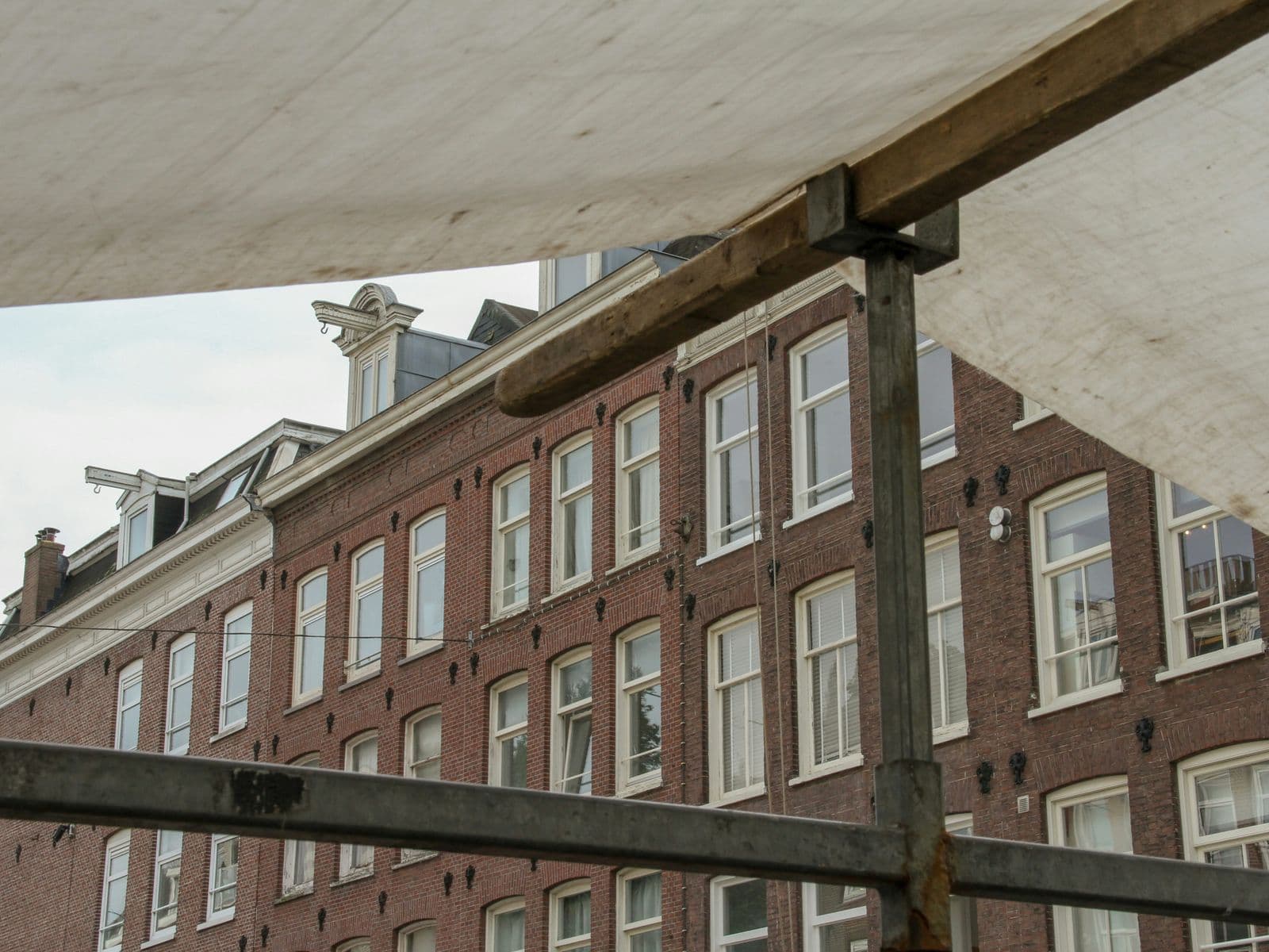 Bakstenen gevels met witte kozijnen, gezien vanaf een steiger